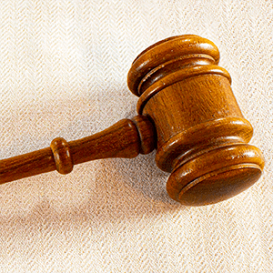 Del av en träklubba som ligger på en vit bordsduk.